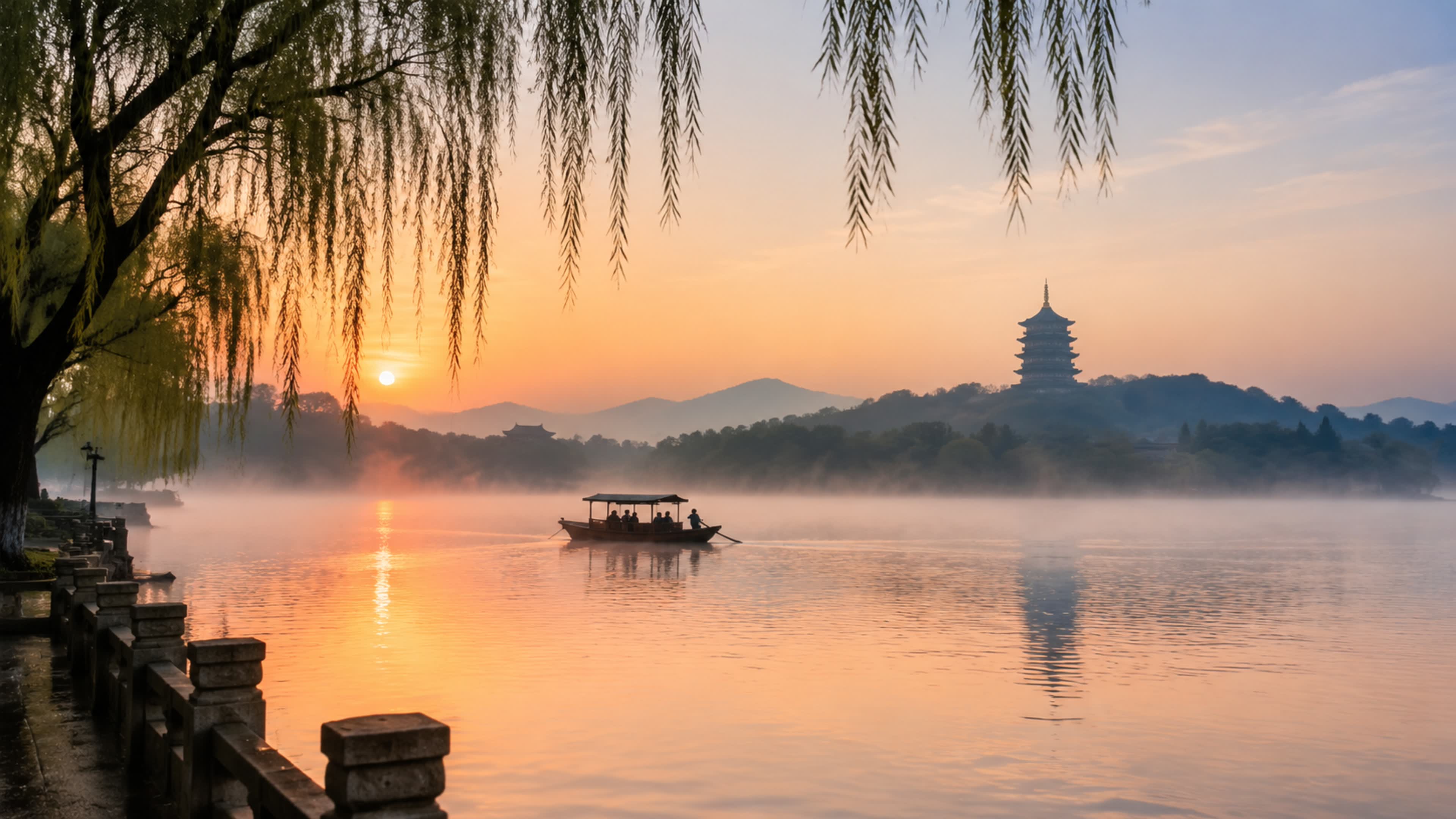 Morning mist over West Lake in Hangzhou with willows and a distant pagoda