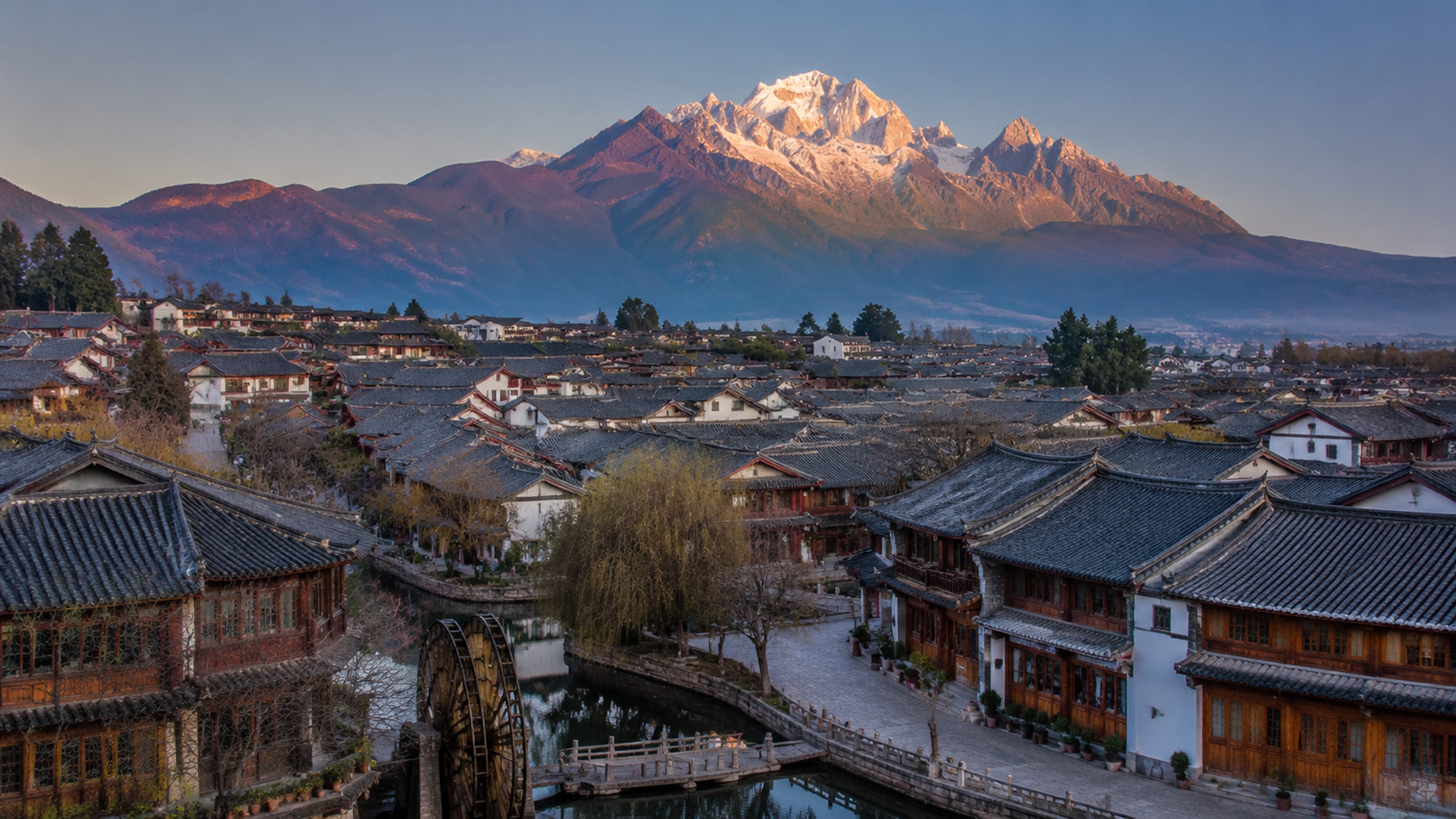 Lijiang Old Town rooftops with Jade Dragon Snow Mountain at dawn