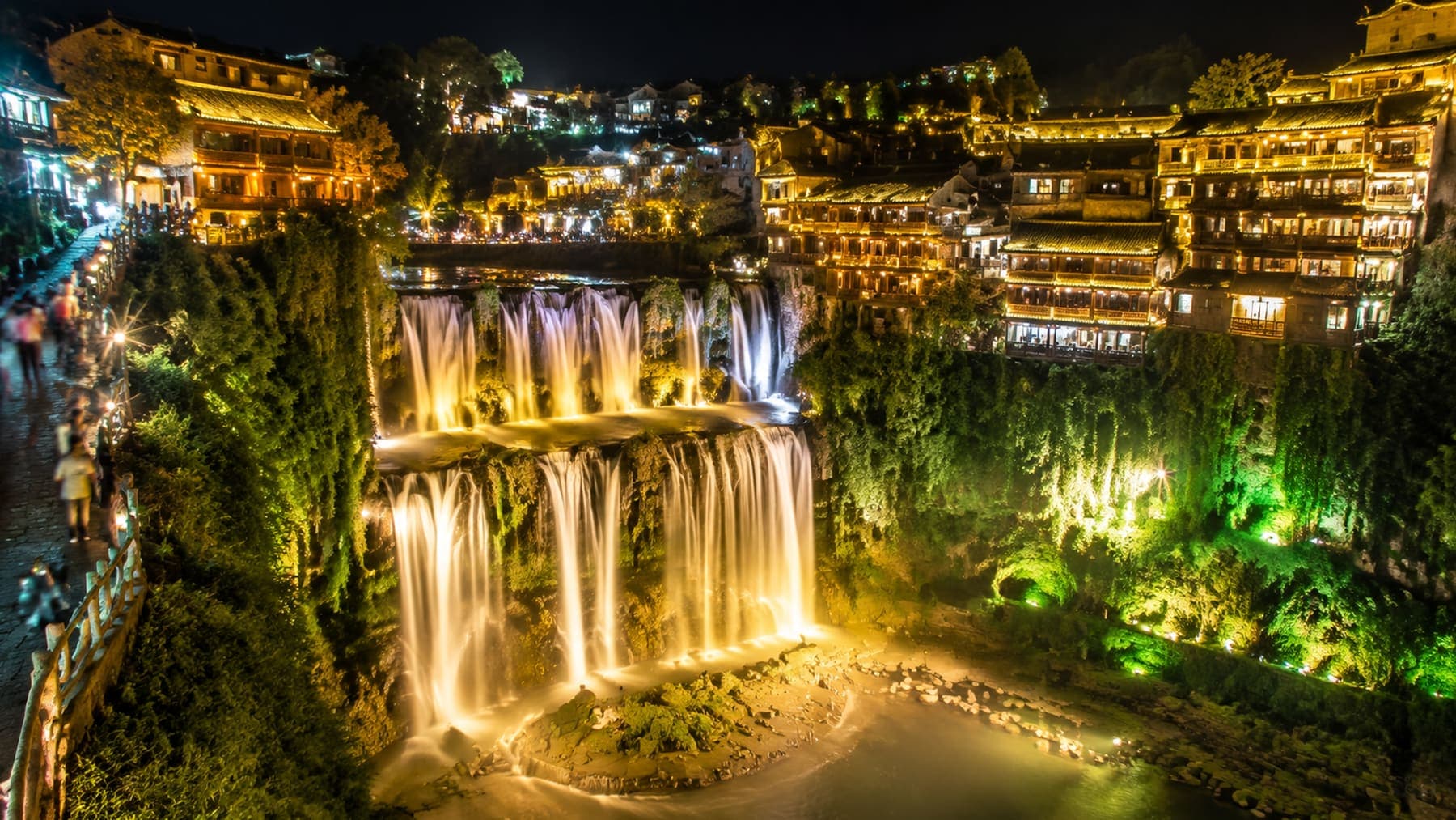 Furong Town waterfall and old houses lit up at night