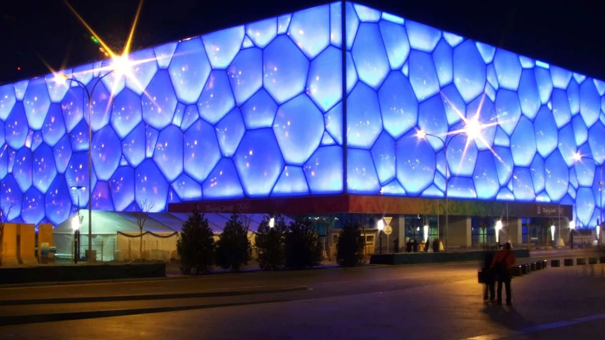The Water Cube national aquatics centre at night, its bubble-like ETFE facade glowing blue